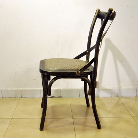 Silla de comedor vintage con estructura de acero y asiento de cuero.